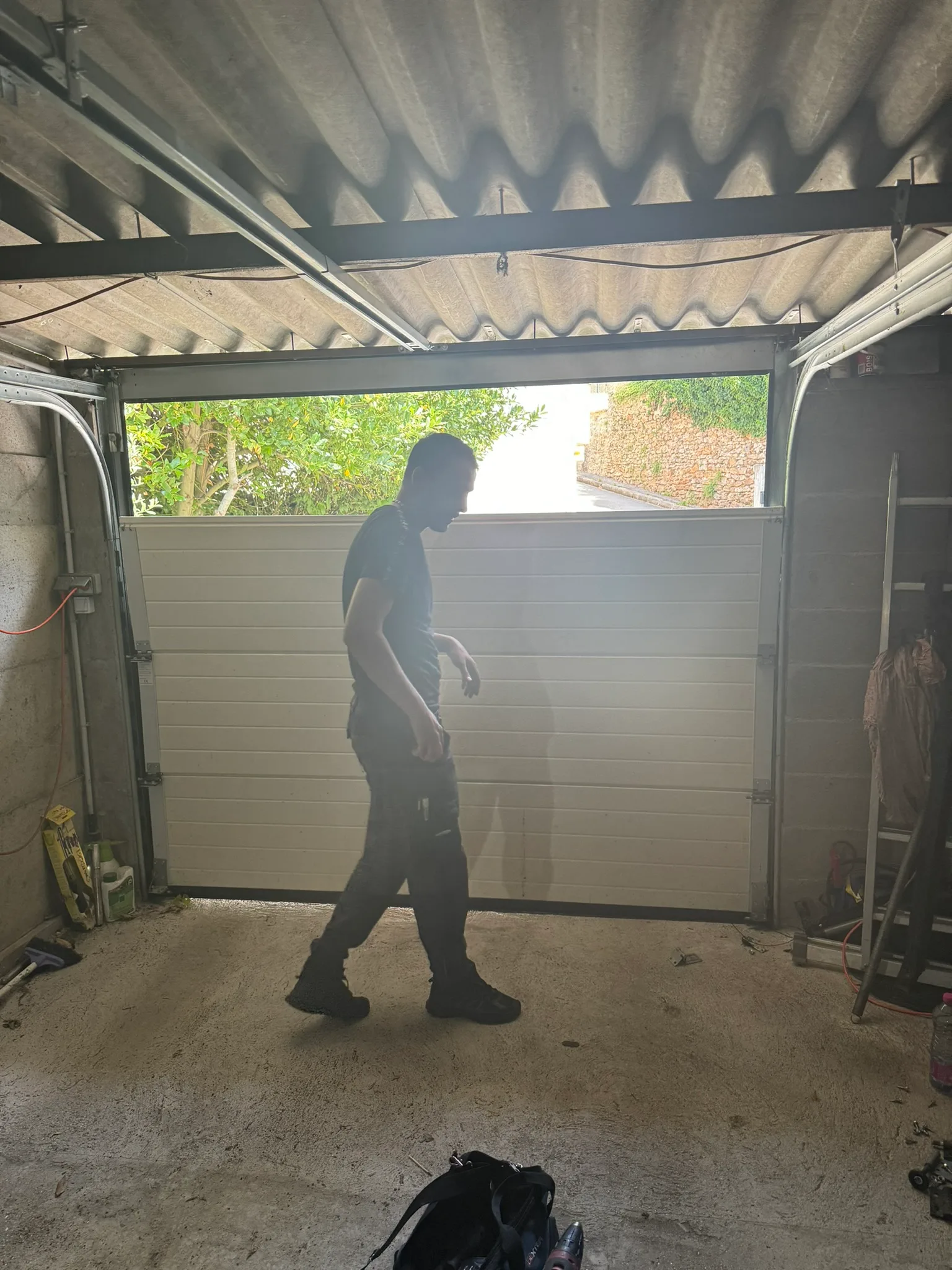 Technicien remplaçant le panneau abîmé d’une porte de garage sectionnelle
